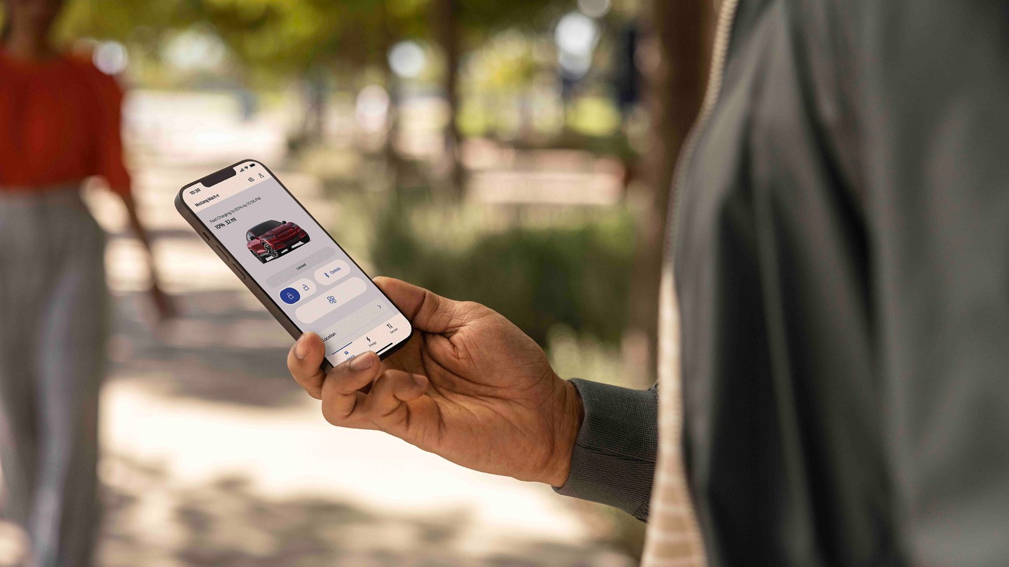 Man looking at smartphone with FordPass App open