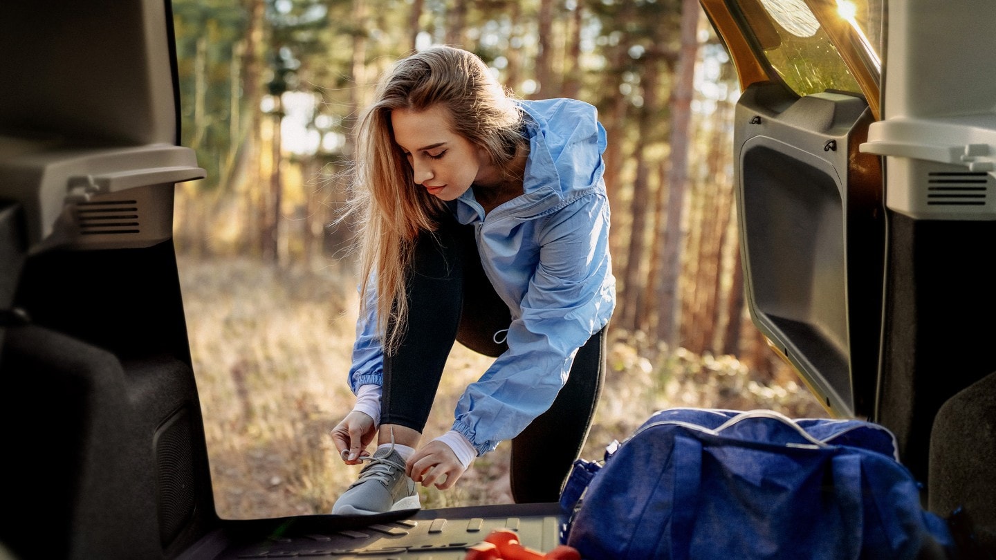 Woman lacing shoes in ford vehicle door interior